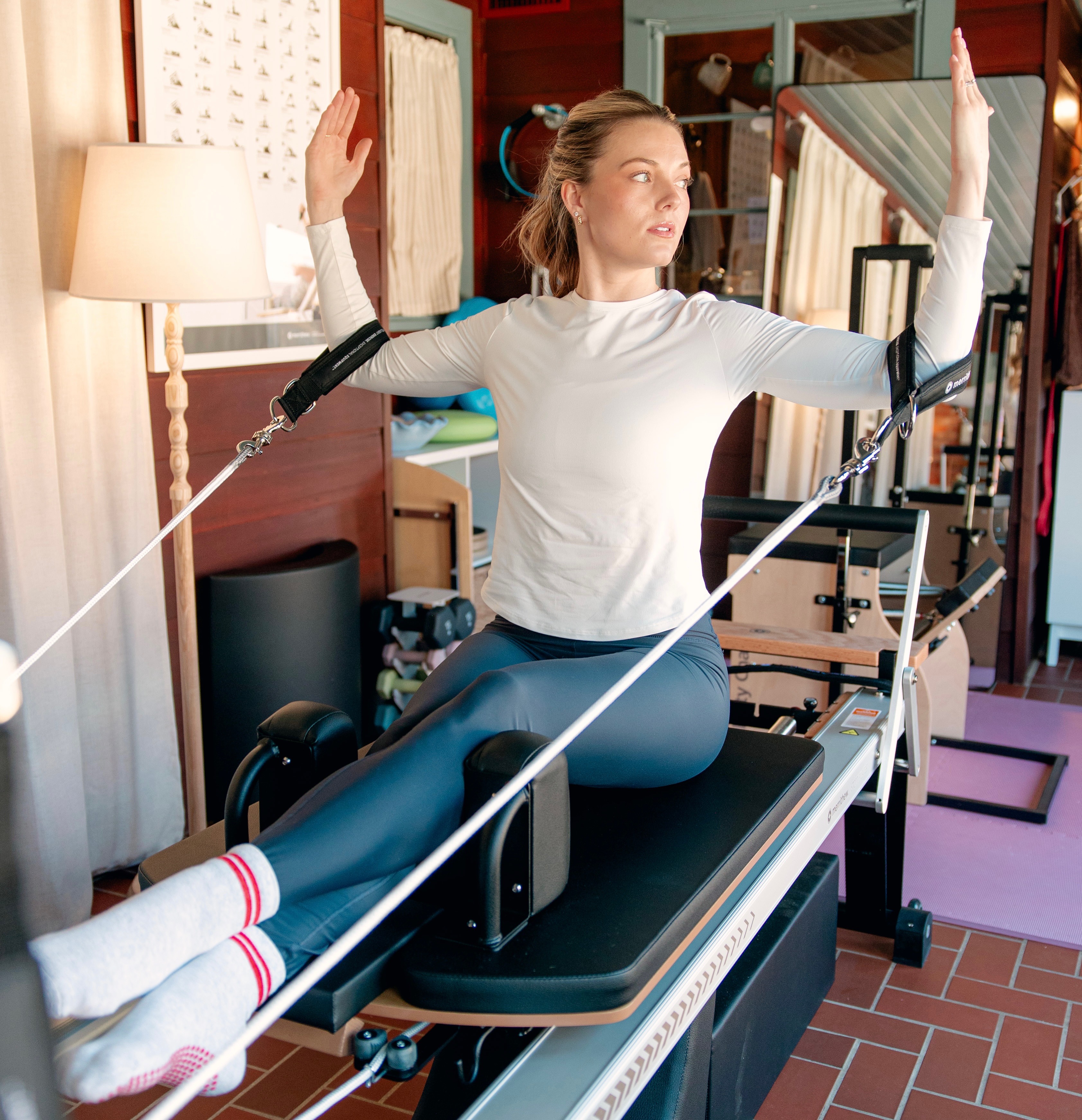 Channing practicing Clinical Pilates with straps on a Reformer